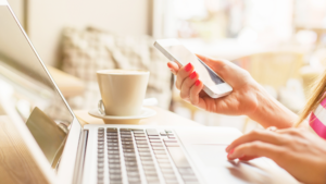Freelancer typing on a laptop and holding a cellphone