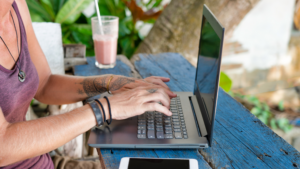 Digital nomad works at her laptop in an outdoor restaurant